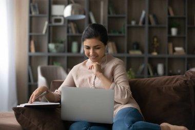 Mutlu Hintli kadın evdeki bilgisayarda çalışıyor.
