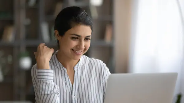 Usmívající se indická žena pracovat online na notebooku — Stock fotografie