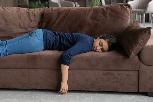 Femme indienne épuisée dormir sur le canapé à la maison — Photo