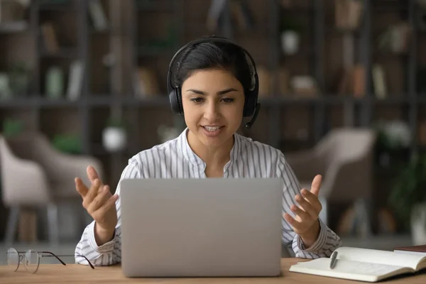 Mladá indická žena ve sluchátkách mluvit na webkameru hovor — Stock fotografie