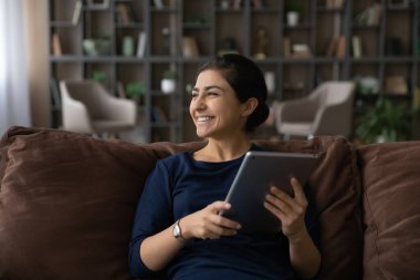 Gülümseyen Hintli kadın tablet kullanarak rüya görüyor.