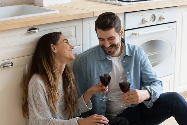 Paar sitzt auf dem Boden und trinkt Wein gegen Müdigkeit beim Umzug — Stockfoto