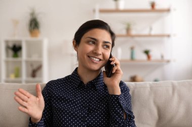 Yakın plan heyecanlı Hintli kadın telefonda konuşuyor, eğleniyor.