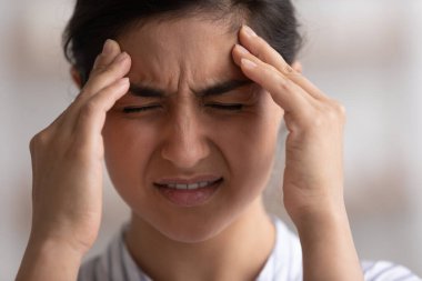 Kafasından vurulmuş mutsuz Hintli kadın, şiddetli bir baş ağrısı hissediyor.