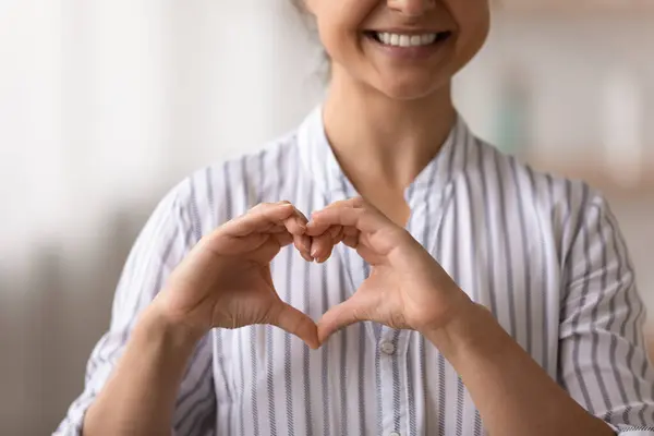Close up cropped of smiling Indian woman showing heart gesture — Stock Photo, Image