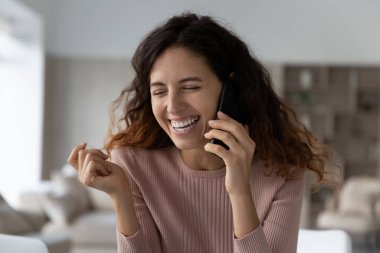 Gülümseyen Latin kadın cep telefonuyla güler.