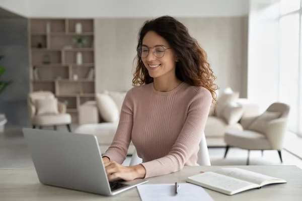 Smiling Hispanic woman work online on laptop at home — Photo