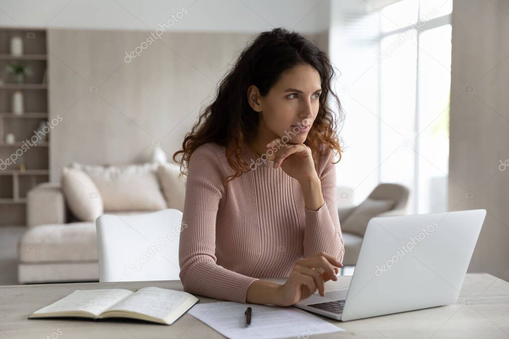 Pensive Latino woman work on laptop thinking