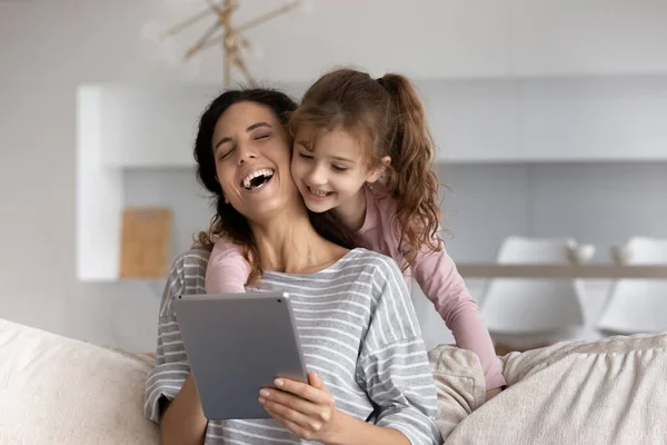 Feliz joven latina mamá y su hija uso tableta — Foto de Stock