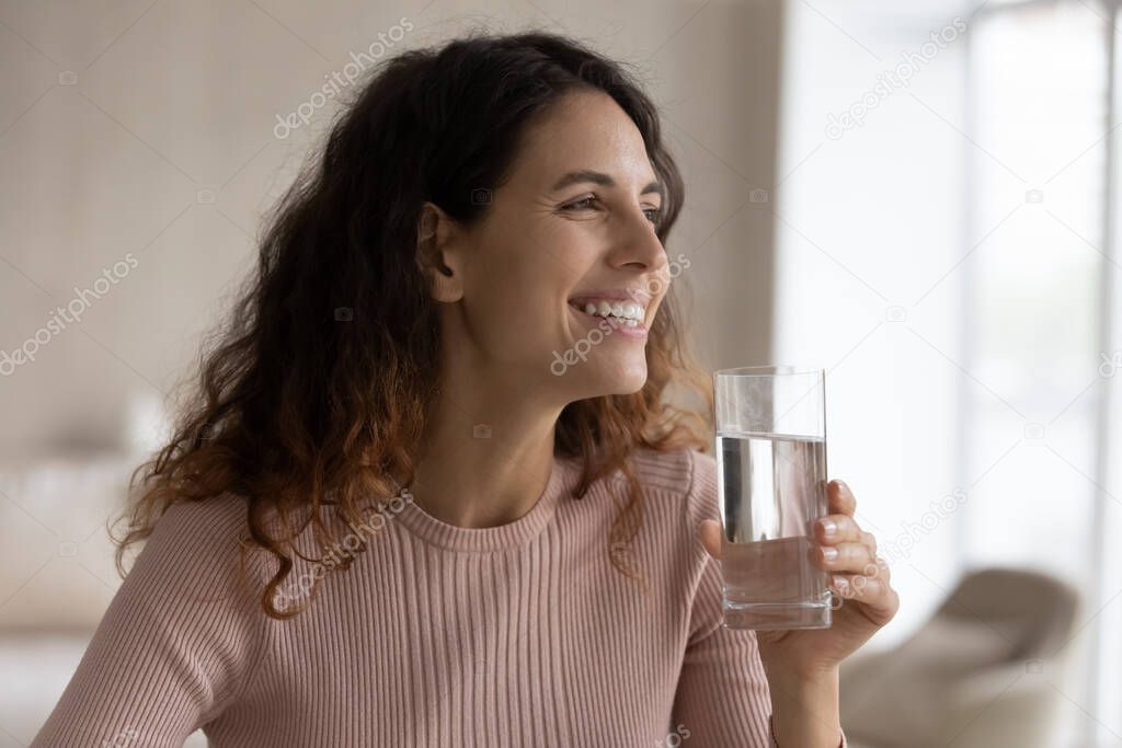 Smiling Latin woman feel thirsty drink water