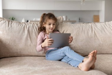 Küçük etnik kız çocuğu evde tablet kullanıyor
