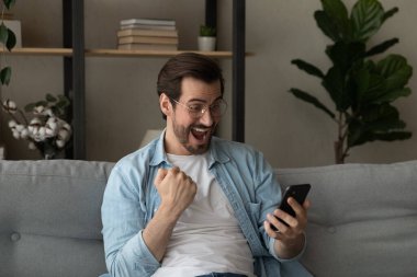 Adam sevinçle cep telefonu çığlıklarına bakıyor. Harika haberleri kutluyor.
