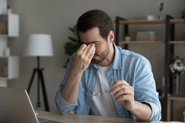 Moe zakenman na laptop gebruik gevoel eyestrain neemt af bril — Stockfoto