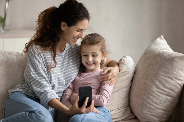 Smiling Latino mother and daughter have webcam call on smartphone — kuvapankkivalokuva