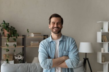 İyimser, 30 'lu yaşlarda, kolları çaprazlanmış, kapalı bir yerde duran beyaz bir adam.