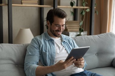 Adam tabletle kanepede dinleniyor. Hafta sonları internet kullanıyor.