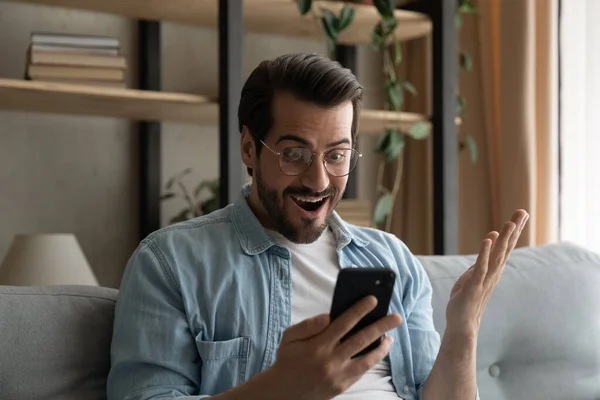 Man holds cellphone gawp at screen read news feels surprised — Stock Photo, Image