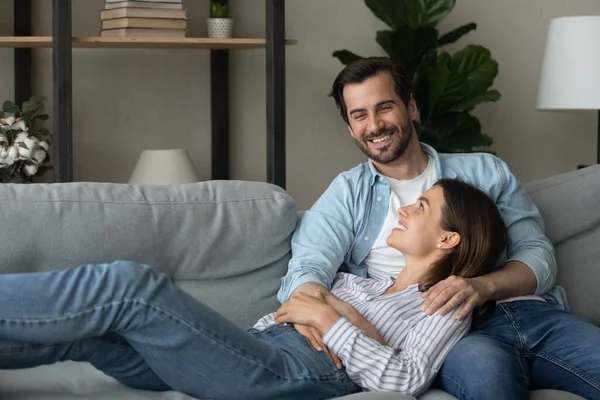 Young couple relaxing on comfy couch in living room — Stockfoto