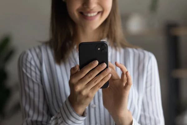 Mujer sonriente sosteniendo teléfono inteligente, vista de cerca — Foto de Stock