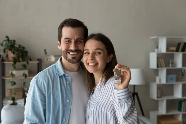 Junges Paar kaufte neues Haus und zeigte Schlüssel vor der Kamera — Stockfoto