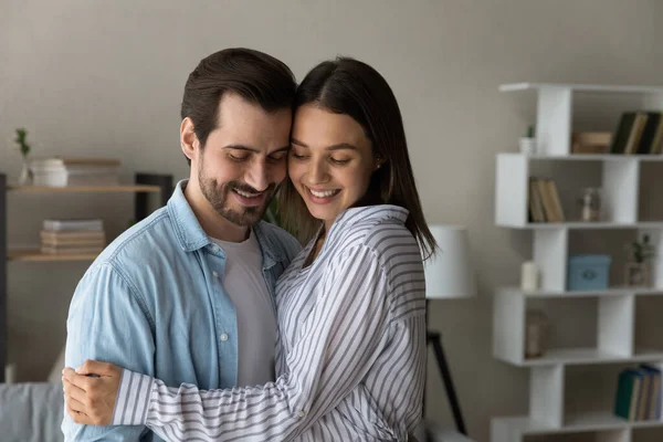 Couple in love cuddling standing inside of modern house — Stockfoto