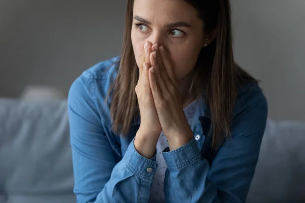 Female sit indoor looks into distance feels horrified by news — Fotografia de Stock