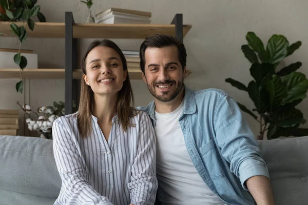 Beautiful married couple sit on sofa smile look at camera — Stock fotografie