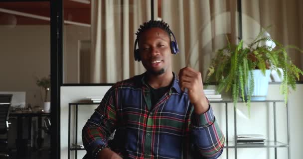 African man wear headphones looks at camera start videocall communication — Stock Video