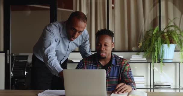 African mentor explain software, provide professional guidance to young intern — Stock video