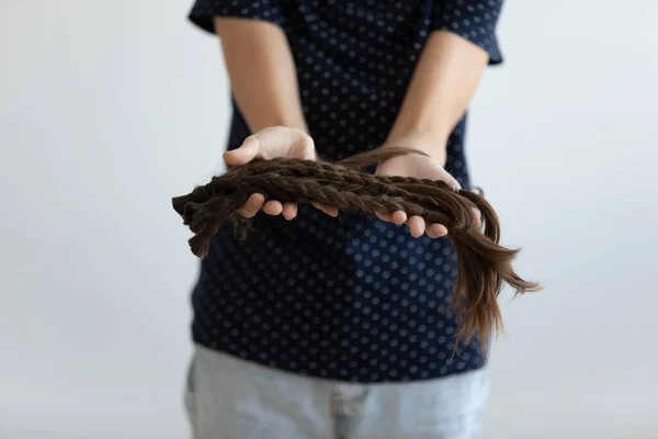 Close up young woman holding braided hair in hands. — Stock Photo, Image