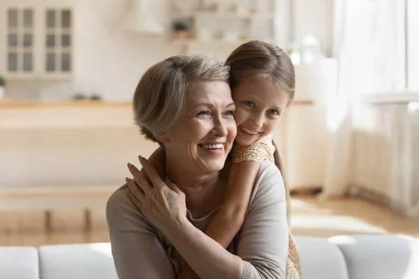 Head shot smiling mature grandmother piggy backing little granddaughter — Stock Photo, Image