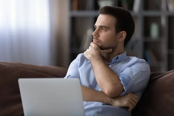 Contemplative young man distracted from laptop ponder on project solution — Stock Photo, Image