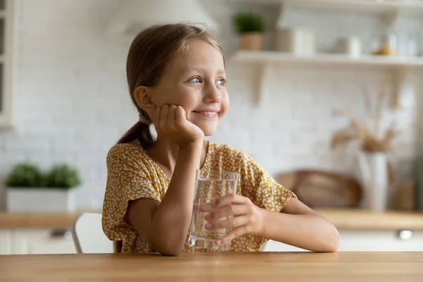 Cabeza disparada sonriente niña soñadora sosteniendo un vaso de agua —  Fotos de Stock