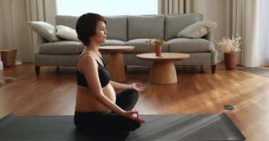 Koca göbekli hamile bir kadın yoga nefes egzersizi yapıyor..