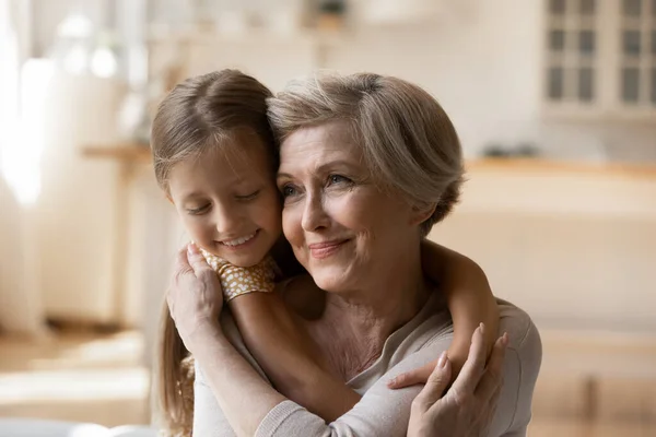 Head shot happy mature woman with adorable little girl hugging — Stock Photo, Image