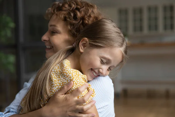 Close up smiling adorable little daughter and loving mother hugging — Stock Photo, Image