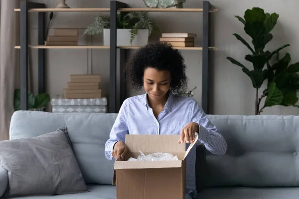 Mujer afroamericana feliz desempaquetar caja con orden de Internet —  Fotos de Stock