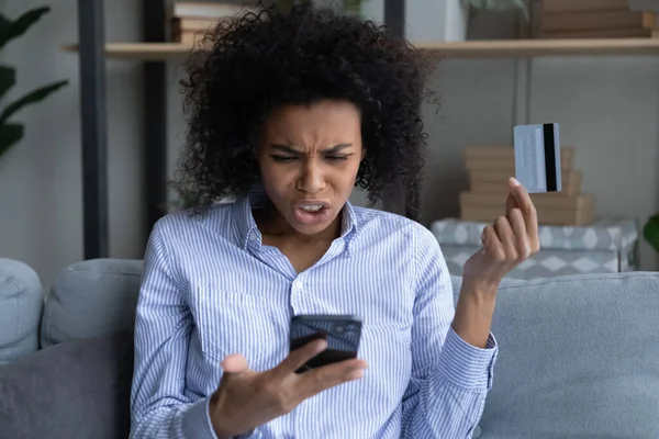 Unhappy biracial woman confused with bank error paying online — Stock Photo, Image