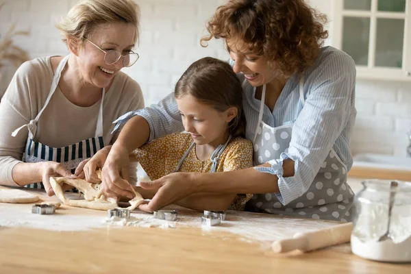 Feliz tres generaciones de mujeres cocinando galletas caseras juntas —  Fotos de Stock