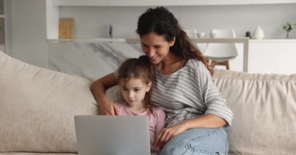 Cura giovane madre e figlia piccola utilizzando il computer. — Video Stock