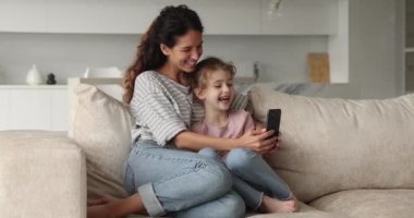 Neşeli genç bir anne ve cep telefonu kullanan küçük bir çocuk..