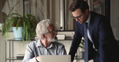 Çok nesilli iş arkadaşları online proje tartışması için dizüstü bilgisayar kullandılar