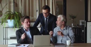 Meslektaşlar yeni iş platformu hakkında konuşan dizüstü bilgisayarlara bakarlar