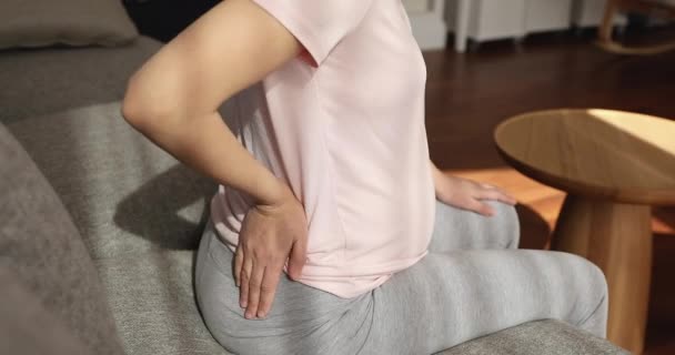 Close-up jonge zwangere vrouw masseren rugspieren. — Stockvideo