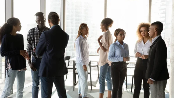 Junge afrikanisch-amerikanische Geschäftsleute unterhalten sich in kleinen Gruppen. — Stockfoto