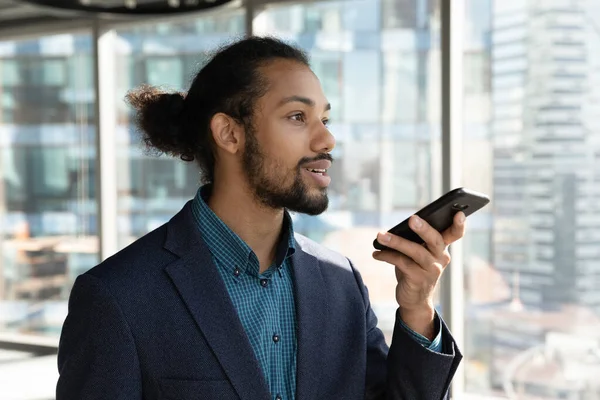 Concentrated young male african manager recording audio message. — Stock Photo, Image