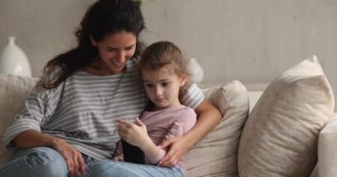 Küçük çocukla akıllı telefon kullanan mutlu bir genç anne..