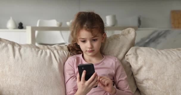 Улыбающаяся маленькая девочка-подросток, использующая мобильный телефон. — стоковое видео