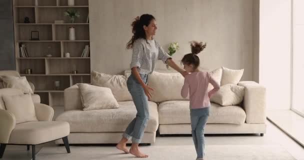 Glückliche junge Mutter und kleine Tochter tanzen zu Hause. — Stockvideo