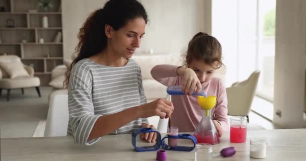 Feliz joven madre haciendo experimentos químicos con hija pequeña. — Vídeos de Stock